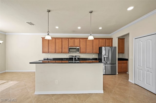 kitchen featuring decorative light fixtures, stainless steel appliances, and an island with sink