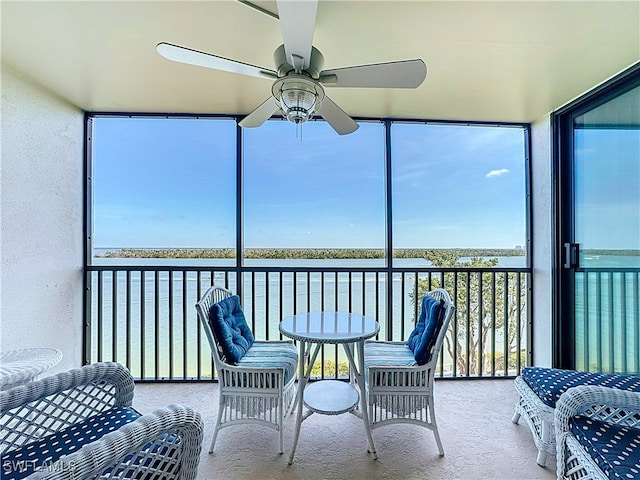 sunroom / solarium with a water view and ceiling fan