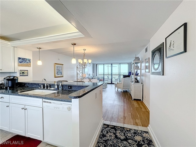 kitchen featuring white cabinetry, dishwasher, light wood-type flooring, and sink