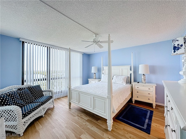 bedroom with ceiling fan, a textured ceiling, and light hardwood / wood-style flooring