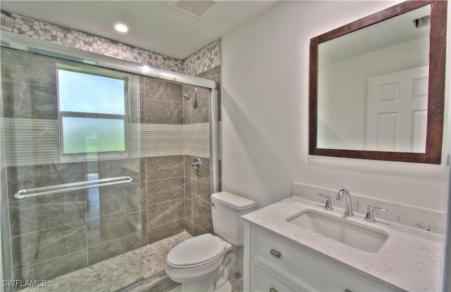 bathroom with vanity, toilet, and a shower with shower door