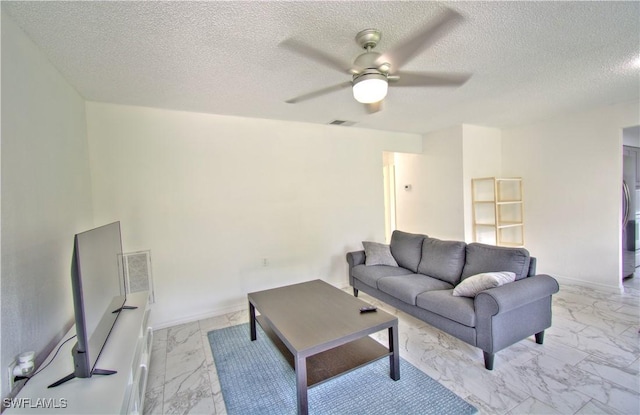 living room with ceiling fan and a textured ceiling