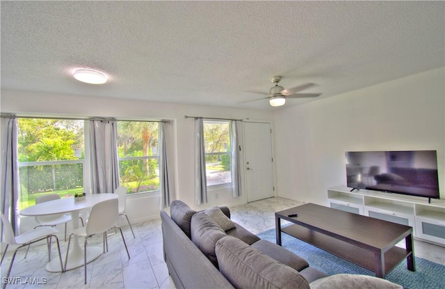 living room with ceiling fan and a textured ceiling