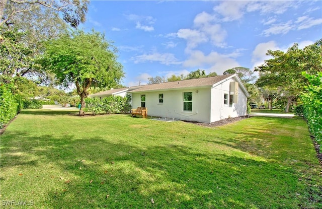 rear view of property featuring a lawn