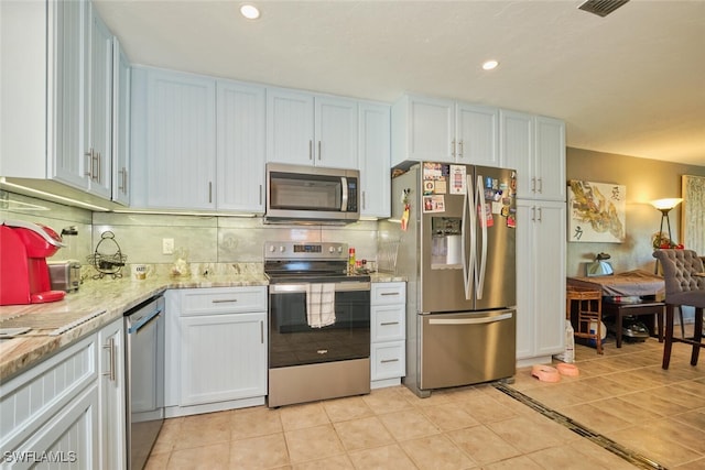 kitchen with white cabinetry, decorative backsplash, and appliances with stainless steel finishes