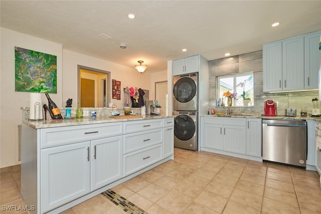 kitchen featuring sink, white cabinetry, dishwasher, stacked washer / dryer, and light stone countertops