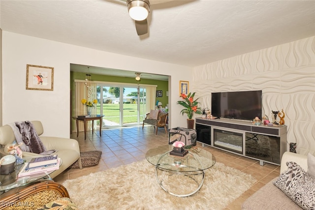 tiled living room with a fireplace and ceiling fan