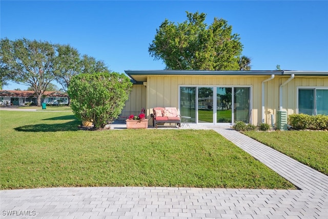 back of property with a patio and a yard