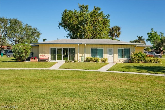 rear view of house featuring a lawn