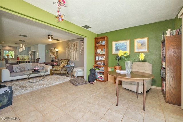 interior space featuring ceiling fan, a textured ceiling, and light tile patterned floors