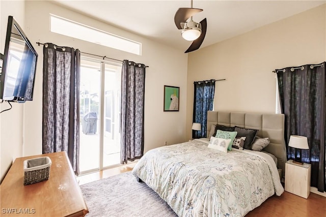 bedroom with access to exterior, wood-type flooring, and ceiling fan