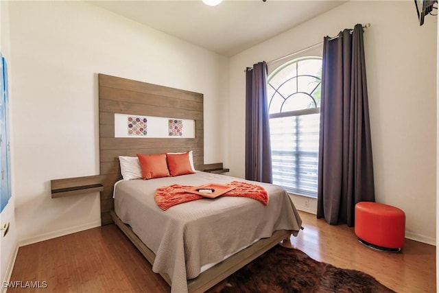 bedroom with wood-type flooring and multiple windows