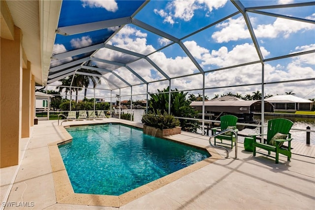 view of swimming pool featuring glass enclosure, a patio area, and a water view