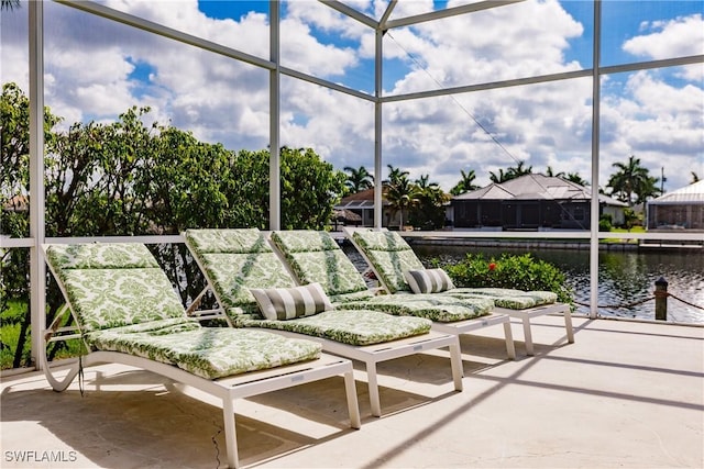 view of patio / terrace with a lanai and a water view