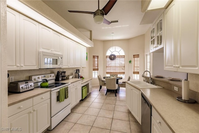 kitchen with white appliances, sink, hanging light fixtures, ceiling fan, and light tile patterned flooring