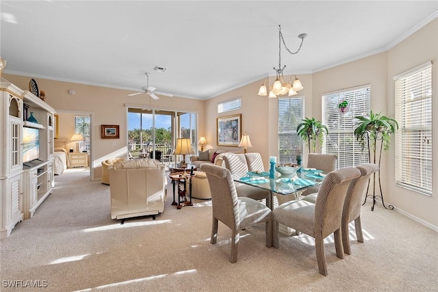 carpeted dining area featuring ceiling fan with notable chandelier and ornamental molding