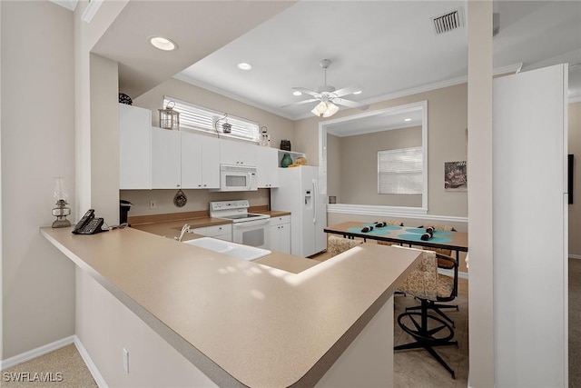 kitchen with white cabinetry, kitchen peninsula, crown molding, white appliances, and light carpet