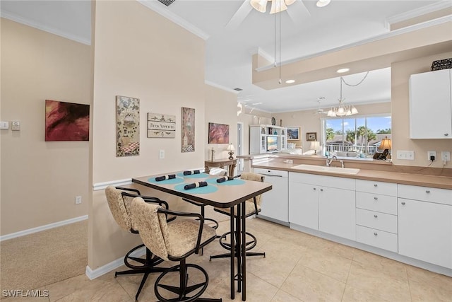 kitchen with dishwasher, white cabinets, hanging light fixtures, and sink