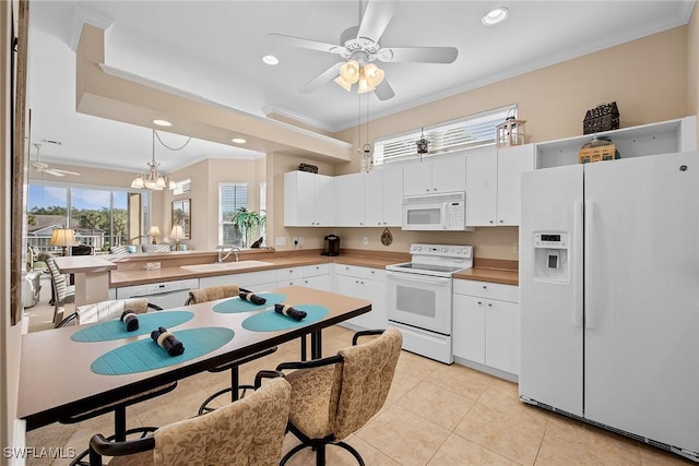 kitchen featuring white appliances, crown molding, sink, decorative light fixtures, and white cabinetry