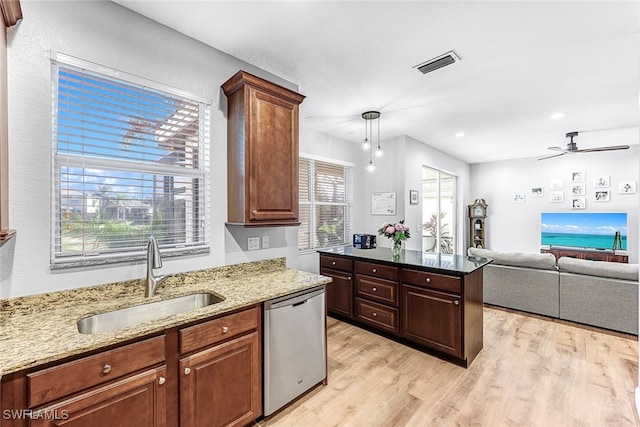 kitchen featuring dishwasher, light wood-type flooring, light stone counters, and sink