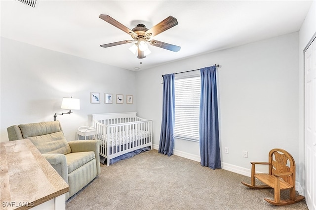 bedroom featuring carpet, a nursery area, and ceiling fan