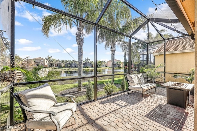 sunroom featuring a water view