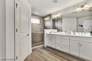 bathroom with a shower with door, vanity, and hardwood / wood-style flooring