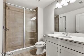 bathroom with vanity, toilet, and a shower with shower door