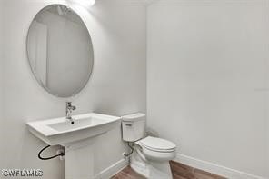 bathroom with hardwood / wood-style flooring, sink, and toilet