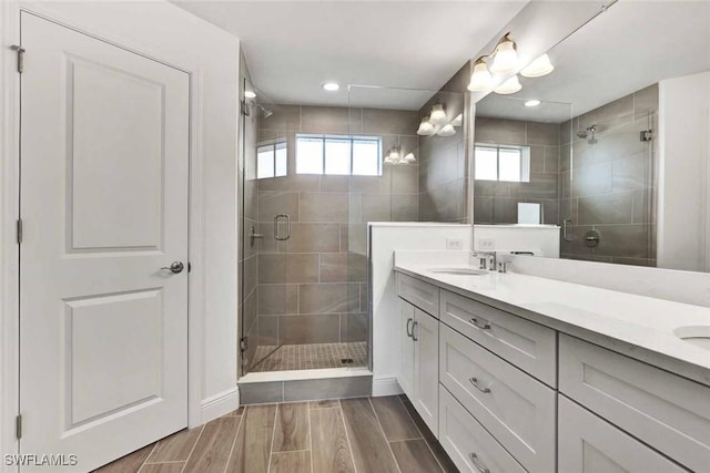 16130 Preservation Blvd, Punta Gorda, FL 33982 - bathroom featuring double vanity, a stall shower, wood finish floors, and baseboards