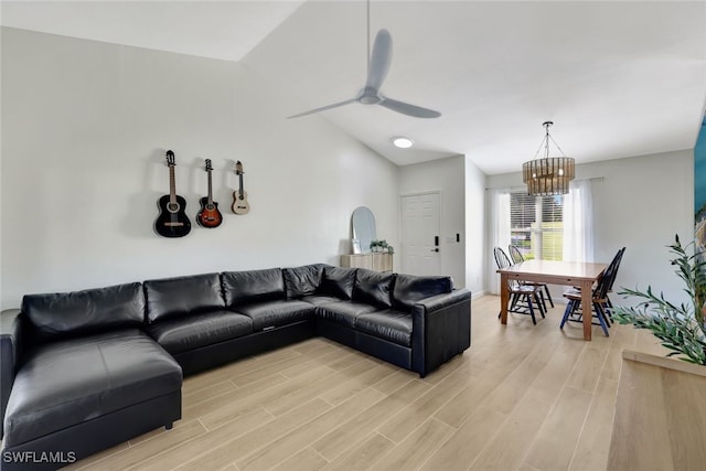 living room with lofted ceiling, light hardwood / wood-style flooring, and ceiling fan with notable chandelier