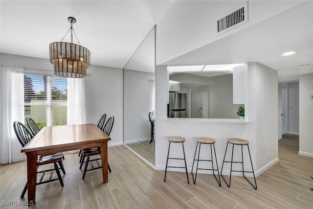 dining area with sink and light hardwood / wood-style floors