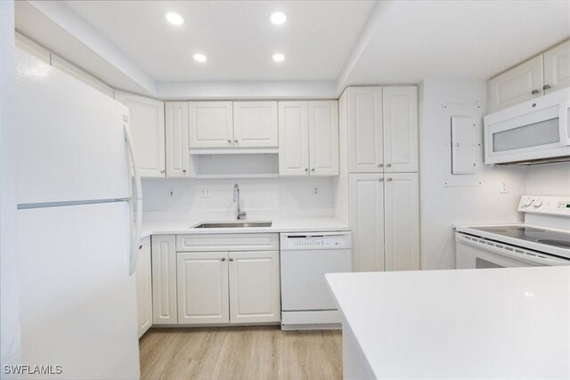 kitchen with white appliances, white cabinetry, and sink