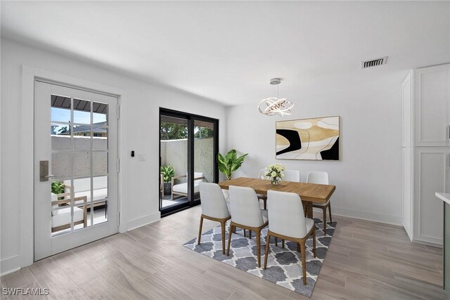 dining area with a chandelier and light wood-type flooring