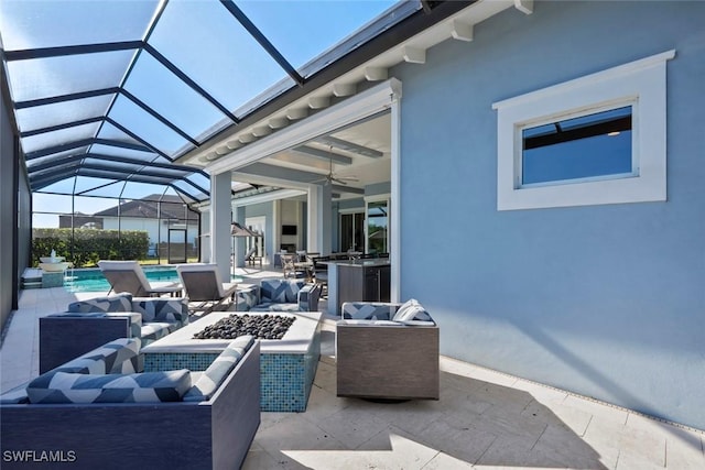 view of patio with an outdoor kitchen, glass enclosure, a fire pit, and ceiling fan