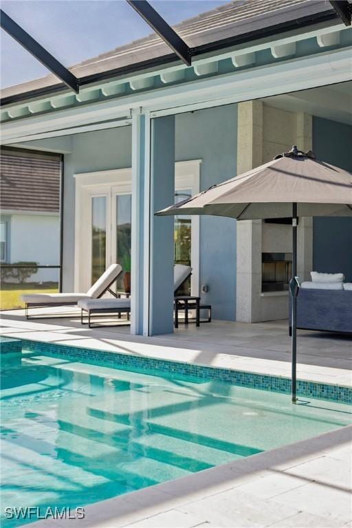 view of pool featuring glass enclosure and a patio area