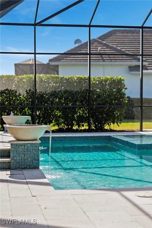 view of pool featuring glass enclosure