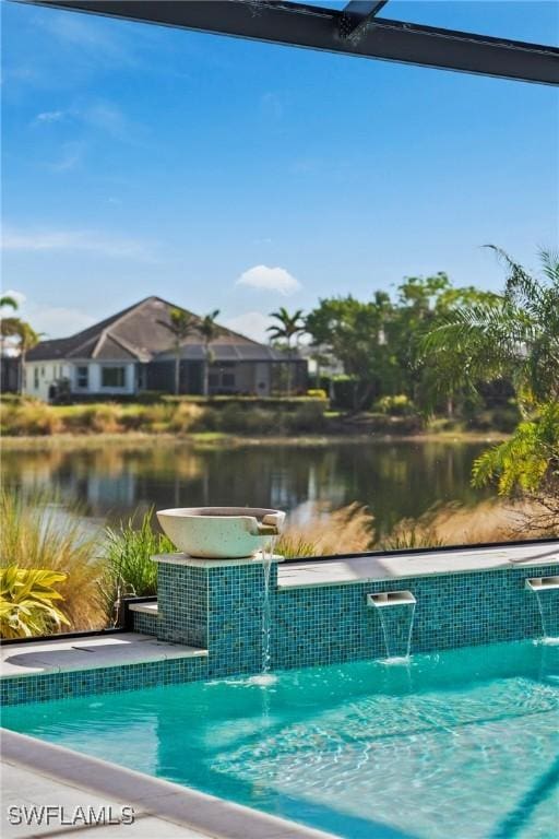 view of swimming pool featuring pool water feature and a water view