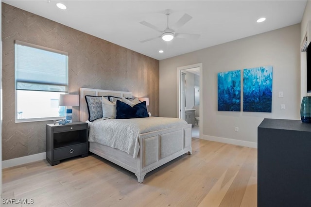 bedroom with ensuite bath, ceiling fan, and light hardwood / wood-style flooring