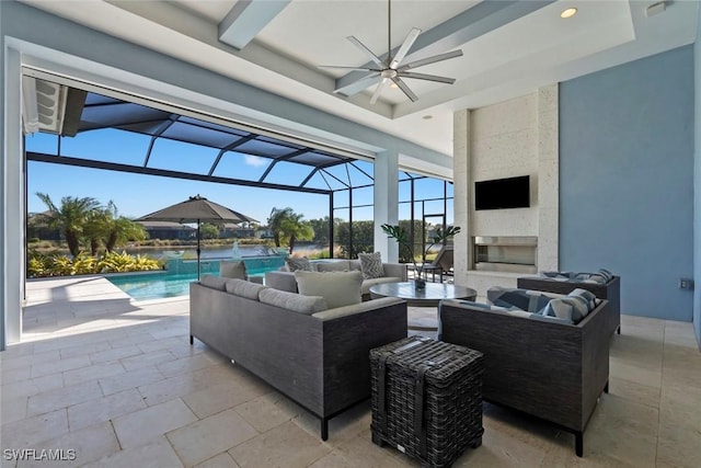 view of patio featuring an outdoor living space with a fireplace, a water view, ceiling fan, and a lanai