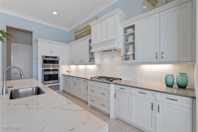 kitchen with appliances with stainless steel finishes, backsplash, white cabinetry, and sink