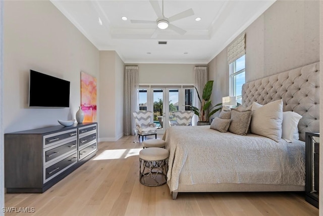 bedroom with access to outside, light wood-type flooring, a tray ceiling, and ceiling fan