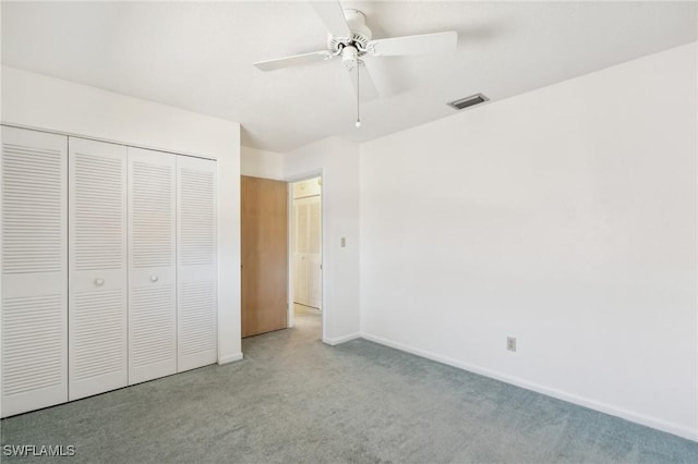 unfurnished bedroom featuring ceiling fan, a closet, and light colored carpet