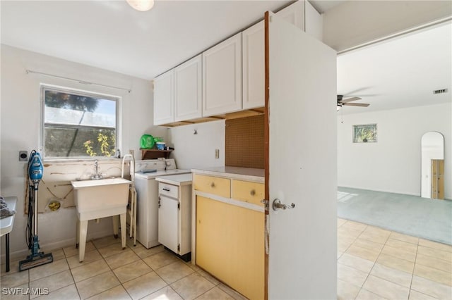 235 Thistle Ct, Lehigh Acres, FL 33936 - washroom with washer / clothes dryer, cabinet space, ceiling fan, light tile patterned floors, and arched walkways