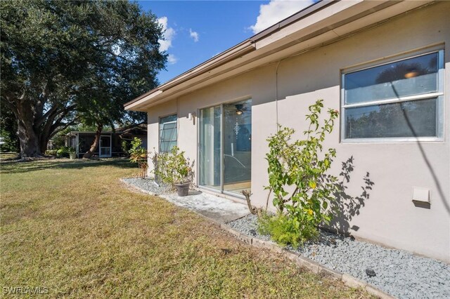 235 Thistle Ct, Lehigh Acres, FL 33936 - exterior space with stucco siding and a yard