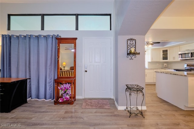 foyer featuring light wood-type flooring and ceiling fan