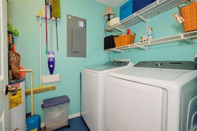 washroom with washing machine and clothes dryer, electric panel, and water heater