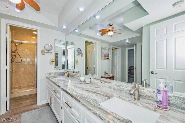 bathroom with wood-type flooring, vanity, an enclosed shower, and ceiling fan