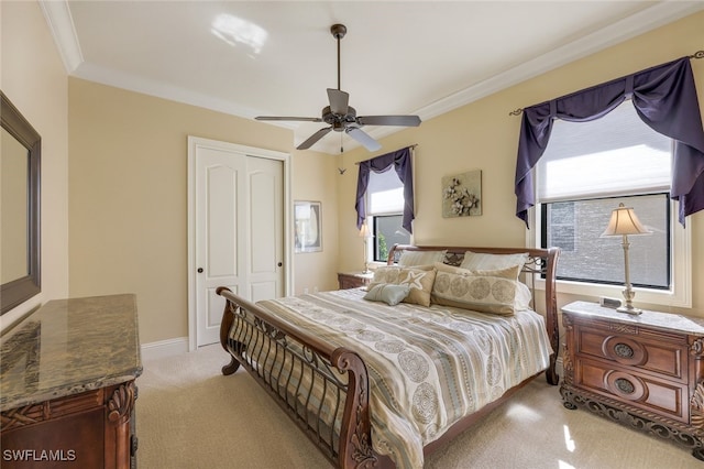 carpeted bedroom with ceiling fan, crown molding, and a closet