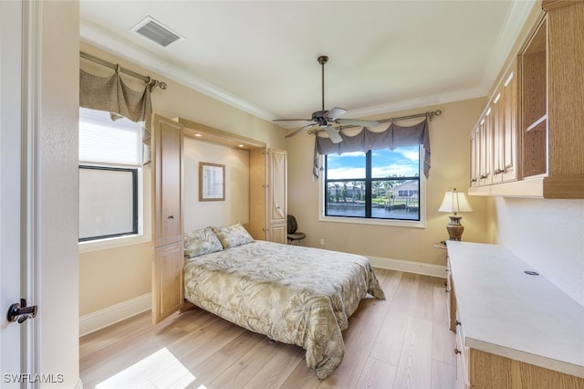 bedroom featuring light hardwood / wood-style floors, multiple windows, crown molding, and ceiling fan